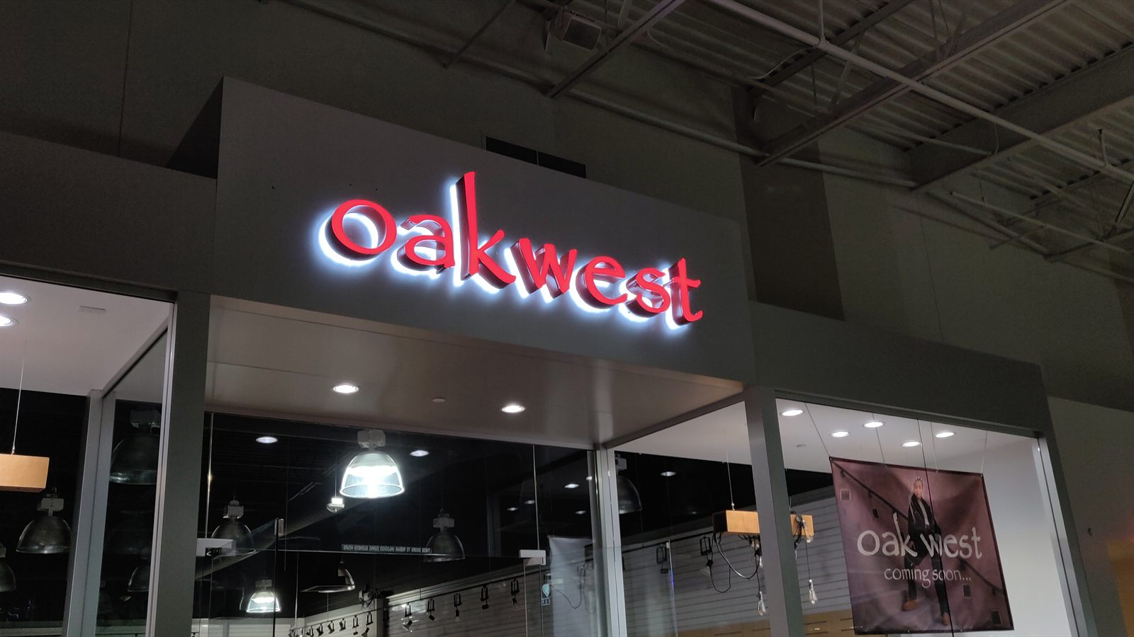 Halo-lit channel letters reading Oakwest, glowing on a storefront fascia at night
