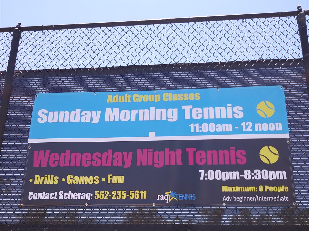 Printed banner grommeted to a tennis court fence listing adult group class days and times