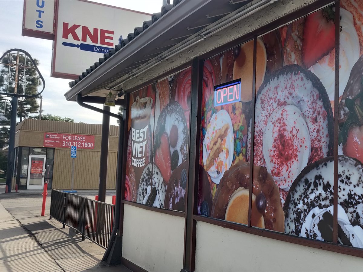 Large printed window graphics showing food photography across a restaurant storefront